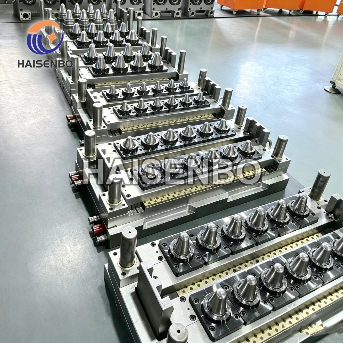 Rows of Haisenbo PET preform mold halves with conical cavities lined up in the workshop